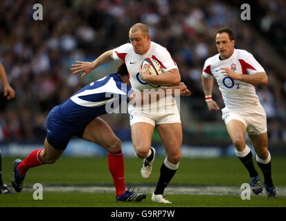 Der englische Mike Tindall (Mitte) entgeht dem französischen Yannick Jauzion (links) während des RBS 6 Nations Championship-Spiels im Twickenham Stadium, London. Stockfoto