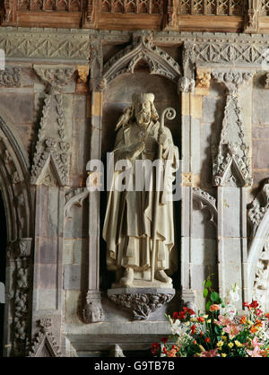 Moderne Statue von St. David (Dewi Sant), Schutzpatron von Wales, platziert in einer Nische auf einem C14th Stein Bildschirm in der Kathedrale von St. Davids, Pembrokeshire. Stockfoto