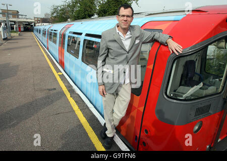 Künstler Jim Isermann mit der mit seinem Entwurf gemalten U-Bahn als Teil der laufenden Piccadilly-Linie Hundertjahrfeier, an der U-Bahnstation Northfields, West London. Stockfoto