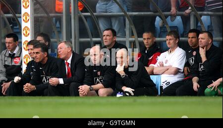 Rio Ferdinand von Manchester United sitzt depriziert hinter Manager Sir Alex Ferguson nach dem Verletzten Stockfoto