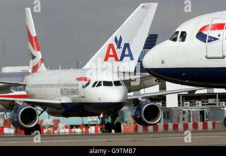 Ein Airbus-Taxi von British Airways passiert am Flughafen Heathrow die Heckflossen von American Airlines und United Airlines. Stockfoto