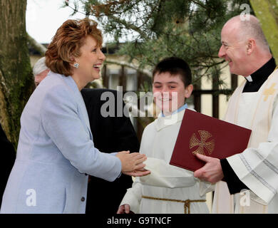 Die irische Präsidentin Mary McAleese wird vom Vorsitzenden des Rates der Gouverneure, Pater Con Boyle, am St. Benedict's College in Randalstown in Co Antrim begrüßt. Stockfoto