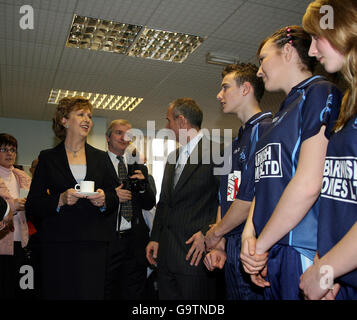Die irische Präsidentin Mary McAleese hält eine Tasse Tee, während sie und ihr Ehemann Martin (Mitte - Profil) Schüler am St. Benedict's College in Randalstown in Co Antrim treffen. Stockfoto