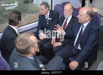 Konservative Partei der Schattentransport-Sekretär Chris Grayling (rechts) spricht mit David Cameron (links) und einer Gruppe von Transport- und ratsbeamten während einer Fahrt im Elektrozug in Leeds. Stockfoto