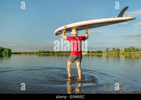 Start Stand up Paddleboard auf einem ruhigen See in northern Colorado mit einer Frühsommer-Landschaft Stockfoto