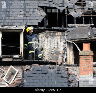 Ein Feuerwehrmann auf einem Gebäude, dessen Dach nach einem Bürogebäude gegenüber in der Dale Street in Manchester in Brand gesteckt wurde, wurde heute Morgen durch einen Brand zerstört. Stockfoto