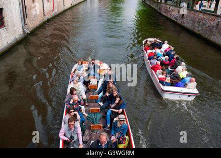 Touristen genießen eine Bootsfahrt auf den Kanälen von Brügge in Belgien. Stockfoto