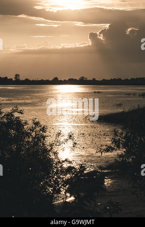 Sommer Sonnenuntergang über See und einsame Boot am Ufer Stockfoto