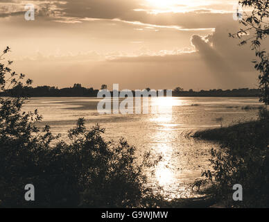 Sommer Sonnenuntergang über See und einsame Boot am Ufer Stockfoto