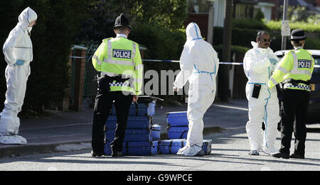 Polizeibeamte stehen auf der Straße vor dem Haus, wo ein 12-jähriges Mädchen schwer verletzt wurde, nachdem es in der Gegend von Gorton in Manchester auf den Kopf geschossen wurde. Stockfoto