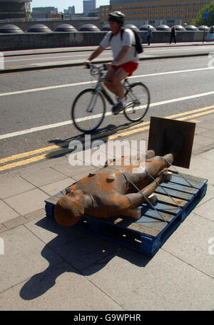 Die gusseiserne Skulptur eines Mannes des Künstlers Antony Gormley liegt auf der Waterloo Bridge in London, bevor sie als Teil von Gormleys neuem Hauptkunstwerk „Event Horizon“ installiert wurde. Stockfoto