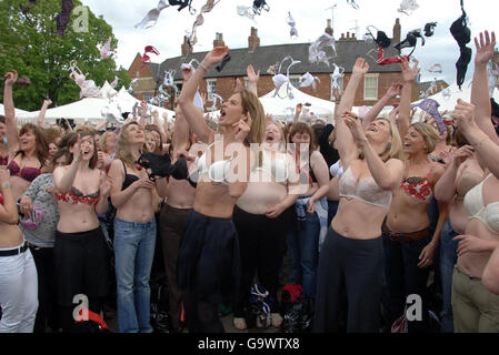 Die Fernsehmoderatoren Trinny Woodall (vorne links) und Susannah Constantine (vorne rechts) führen fast 900 Frauen an, die ihre alten BHs auf dem Rothwell-Stadtplatz in Rothwell, Northamptonshire, in die Luft werfen. Stockfoto