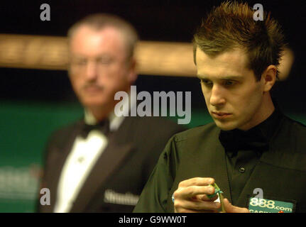 Der Engländer Mark Selby studiert den Tisch, während Schiedsrichter Eirian Williams beim Finale der Snooker-Weltmeisterschaft im Crucible Theatre, Sheffield, zuschaut. Stockfoto