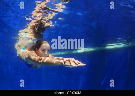 Schöne junge Frau Tauchgang unter Wasser mit Spaß von Pool zu Pool blau. Gesunden, aktiven Lebensstil, Wasseraktivität Menschen sport