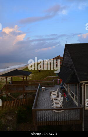 Gewitterwolken am Sonnenaufgang über die Strand-Ferienhäuser an der Atlantikküste am langen Strand an Oak Island North Carolina. Stockfoto