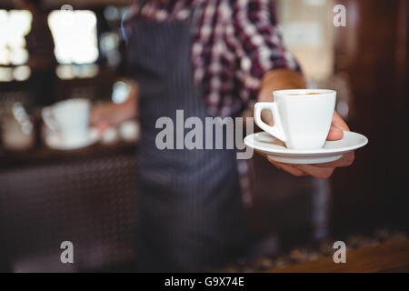 Kellner, die Übergabe eines Kaffees Stockfoto