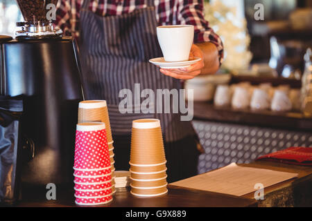 Kellner, die Übergabe eines Kaffees Stockfoto