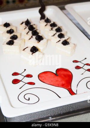 Ein Teller mit Nachtisch ziert ein Muster aus Schokolade und Sirup. Stockfoto