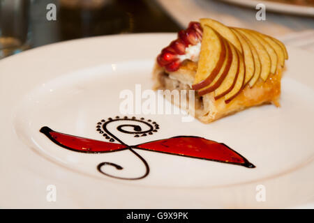 Ein Teller mit Nachtisch ziert ein Muster aus Schokolade und Sirup. Stockfoto