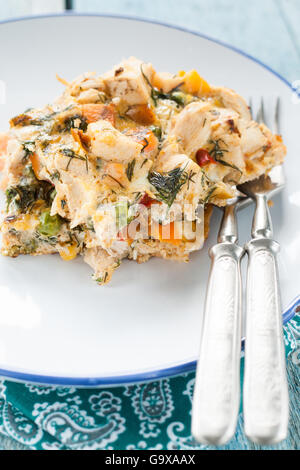 Dienen Sie die Omelette mit Gemüse und Hühnerfleisch auf einem alten hölzernen Hintergrund der alten Vorlegebesteck Stockfoto