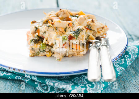 Dienen Sie die Omelette mit Gemüse und Hühnerfleisch auf einem alten hölzernen Hintergrund der alten Vorlegebesteck Stockfoto