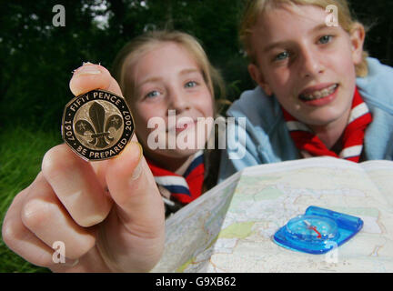 Scouts Bethany Emsley (links) und Amy Jones, beide 11, halten eine Karte und eine neue 50 Pence Goldmünze im Scouts National Adventure Center im Gilwell Park, Essex. Stockfoto