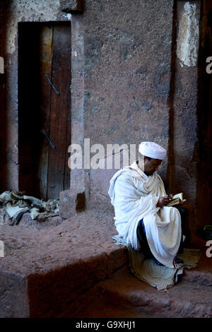 Priester Lesen der Bibel in Wette Meskel Kirche (Teil der nordwestlichen Gruppe von Kirchen in Lalibela). UNESCO-Weltkulturerbe. Lalibela. Äthiopien, Dezember 2014. Stockfoto