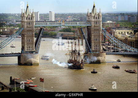 Theborg - eine Replik eines Ostindischen Handelsmannes aus dem 18. Jahrhundert - feuert seine Kanonen, nachdem er unter der Tower Bridge vorbeiging, für die seine Straßentore besonders geöffnet wurden. Stockfoto