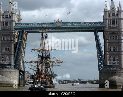 Theborg - eine Replik eines Ostindischen Handelsmannes aus dem 18. Jahrhundert - feuert seine Kanonen, nachdem er unter der Tower Bridge vorbeiging, für die seine Straßentore besonders geöffnet wurden. Stockfoto