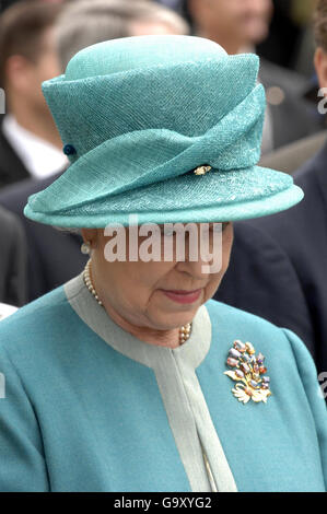 Die britische Königin Elizabeth II. Sieht am zweiten Tag ihres US-Besuches mit großen Augen aus, als ein Schiff im historischen Jamestown Kanonen abfeuert. Stockfoto