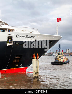 Liverpool, Merseyside, UK. 2. Juli 2016. Die 211 m hohen Queen Elizabeth liner anreisen, die Hundertjahrfeier der Cunard Gebäude eines der Wahrzeichen Liverpools Gebäude, machen den Pier Head Drei Grazien zu feiern. Der Kapitän der Königin Elizabeth II., Inger Klein Olsen - das erste weibliche Kapitän eines Cunard Schiff, ist der Sitz der die volle Länge der Cunard Building auf der Faser führt zu enthüllen. Credit: MediaWorldImages/Alamy leben Nachrichten Stockfoto