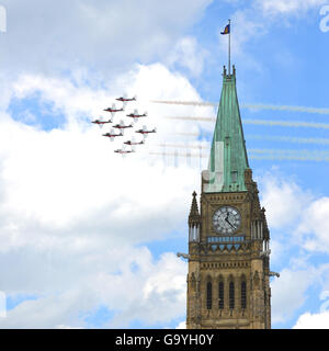 Ottawa, Kanada - 1. Juli 2016: Canadian Air Demonstration Squadron, bekannt als die Snowbirds durch den Peace Tower als Teil der Canada Day Feier auf dem Parlamentshügel fliegen. Stockfoto