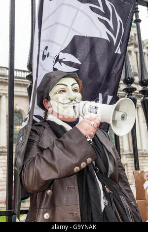 Belfast, UK, Europa. 4. Juli 2016. Eine Frau trägt eine Guido Fawkes/Anonymous Maske mit einer anonymen Flagge gebunden bis vor die Tore der Belfast City Hall Adressierung eine kleine Menschenmenge mit einem Megaphon. Bildnachweis: Bonzo/Alamy Live-Nachrichten Stockfoto