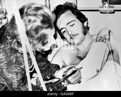 Die Premierministerin Margaret Thatcher, die den Gipsabdruck auf dem Arm des Royal Engineer Corporal Donald Williams aus Cardiff signiert hat, als sie das Musgrave Park Hospital in Belfast während eines Überraschungsbesuchs in der provence besuchte Stockfoto
