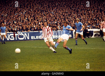 Fußball - League Division One - Manchester City / Stoke City - Maine Road. Manchester City Kapitän Tony Book erzielt trotz der Herausforderung von Harry Burrows von Stoke City das erste Tor Stockfoto