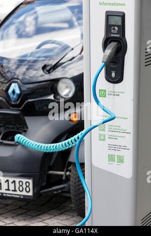 Elektro-Auto, Renault, Plug-in-Station vor modernen Bürogebäude aufgeladen wird. Stockfoto