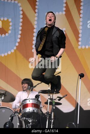 Ricky Wilson von den Kaiser Chiefs springt während ihrer Performance auf der Pyramid Stage beim Glastonbury Festival 2007 auf der Worthy Farm in Pilton, Somerset, in die Luft. Stockfoto