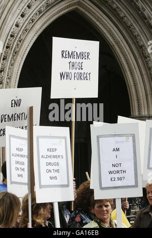 Menschen mit Alzheimer-Krankheit nehmen mit ihren Betreuern am Protest der Alzheimer's Society vor dem Londoner High Court Teil, wo von der Gesellschaft unterstützte Pharmaunternehmen die Entscheidung von Nizza, keine weiteren Mittel für die Finanzierung von Medikamenten gegen Demenz im NHS für Patienten in frühen Stadien der Krankheit zu finanzieren, in Frage stellen. Stockfoto