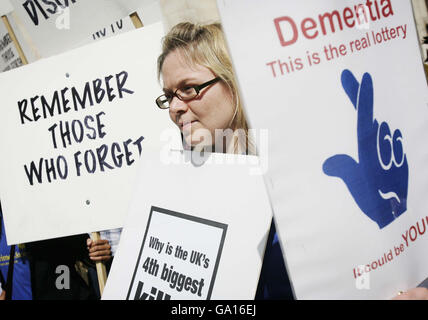 Menschen mit Alzheimer-Krankheit nehmen mit ihren Betreuern am Protest der Alzheimer's Society vor dem Londoner High Court Teil, wo von der Gesellschaft unterstützte Pharmaunternehmen die Entscheidung von Nizza, keine weiteren Mittel für die Finanzierung von Medikamenten gegen Demenz im NHS für Patienten in frühen Stadien der Krankheit zu finanzieren, in Frage stellen. Stockfoto