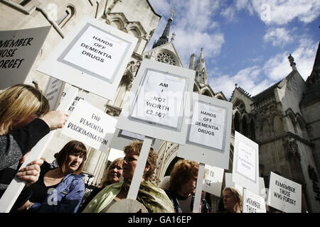 Menschen mit Alzheimer-Krankheit nehmen mit ihren Betreuern am Protest der Alzheimer's Society vor dem Londoner High Court Teil, wo von der Gesellschaft unterstützte Pharmaunternehmen die Entscheidung von Nizza, keine weiteren Mittel für die Finanzierung von Medikamenten gegen Demenz im NHS für Patienten in frühen Stadien der Krankheit zu finanzieren, in Frage stellen. Stockfoto