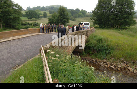 Die Menschen gehen über die Shaken Bridge in Hawnby, in der Nähe von Helmsley, North Yorkshire, nachdem sie nach der Reparatur nach einem Überschwemmungsschaden offiziell wieder eröffnet wurde. Stockfoto