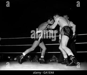 Der Belfaster Freddie Gilroy, der Bantamweighrt-Champion des britischen und britischen Empire, schmeißt es mit dem italienischen Piero Rollo (links) um dessen europäischen Titel in der Wembley Empire Pool-Sportarena aus. Stockfoto