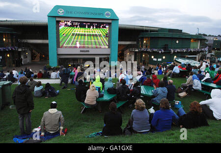 Fans beobachten von Henman Hill aus, wie der britische Tim Henman während der All England Lawn Tennis Championship in Wimbledon den spanischen Carlos Moya spielt. Stockfoto