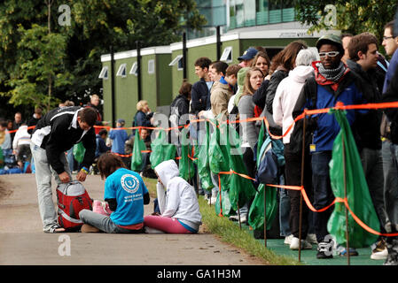 Tennis-Fans warten auf die Handgelenkbänder für Center Court Tickets auf der Church Road am zweiten Tag der All England Lawn Tennis Championship in Wimbledon. Stockfoto