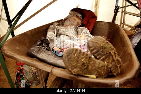 Indigo Bradford, zweieinhalb Jahre alt, aus London, entspannt sich auf dem Glastonbury Festival 2007 auf der Worthy Farm in Pilton, Somerset, in einer Schubkarre im Presszelt. Stockfoto