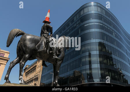 Statue des Herzogs von Wellington mit Verkehr Kegel auf Kopf, mit Blick auf moderne Bürogebäude, Glasgow, Schottland, UK, Stockfoto