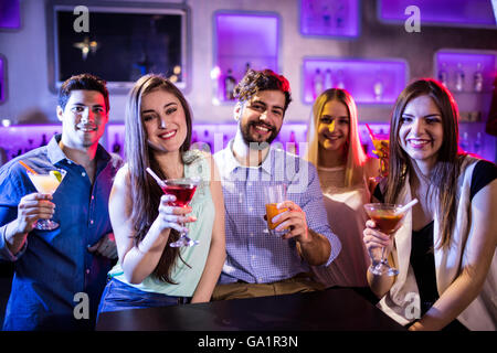 Gruppe von Freunden zeigen cocktail am Tresen Stockfoto