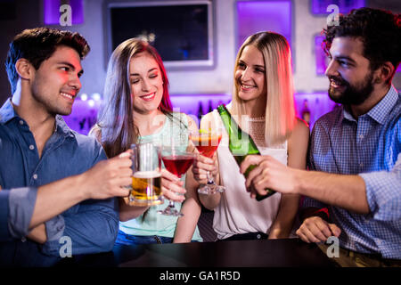 Gruppe von Freunden Toasten cocktail, Bierflasche und Bierglas am Tresen Stockfoto