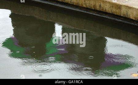 Tennis - Wimbledon Championships 2007 - Tag Sechs - All England Club. Die Fans spiegeln sich in einem Teich wider, während die Regenverzögerungen während der All England Lawn Tennis Championship in Wimbledon spielen. Stockfoto