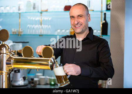 Barkeeper Bier aus bar Pumpe füllen Stockfoto